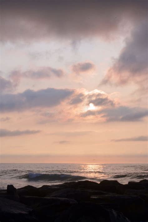 Heavenly Summer Sunrise Over Rock Jetty On The Beach Stock Photo
