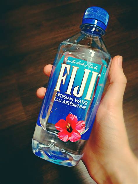 A Hand Holding A Bottle Of Fiji Water