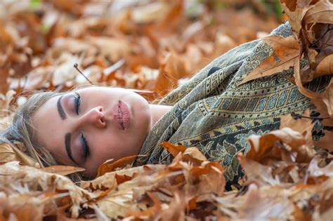 Girl Laying Down In Autumn Leaves
