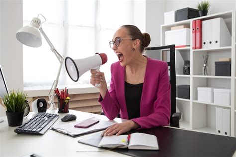 Premium Photo A Girl Screams Into A Loudspeaker In The Office The