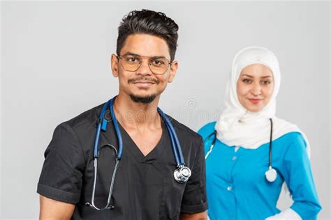 Professional Muslim Doctor Woman And Indian Nurse In Glasses Discuss Tasks Portrait Of