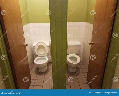 Two Toilets With Stalls In Green And White Bathroom Stock Image Image