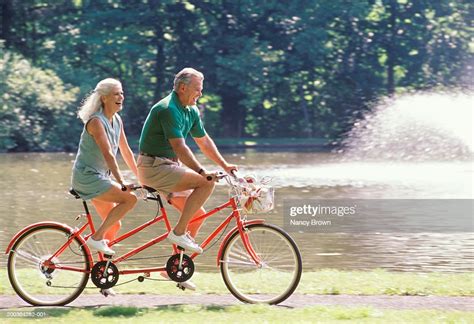 Mature Couple Riding Bicycle For Two Side View Photo Getty Images