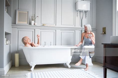 Senior Man In Bath Talking To Wife In Hotel Bathroom High Res Stock