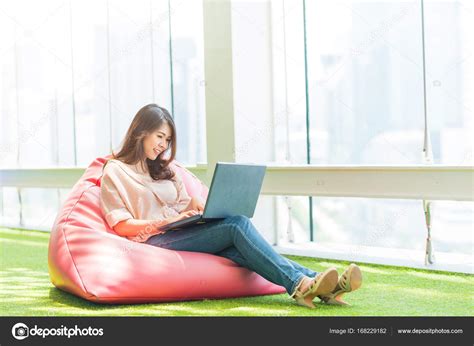 Asian Woman Sitting On Bean Bag While Working With Laptop — Stock Photo