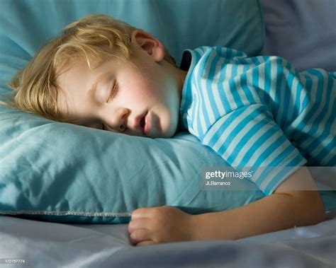 Young Boy In Blue Peacefully Sleeping On A Blue Pillow High Res Stock