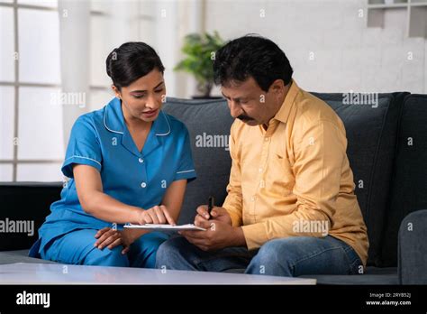 Indian nurse helping recovered patient to fill up hospital medical