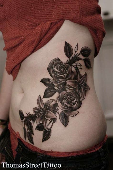 Awesome grey small lily tattoo on bicep. roses and lilies tattoo