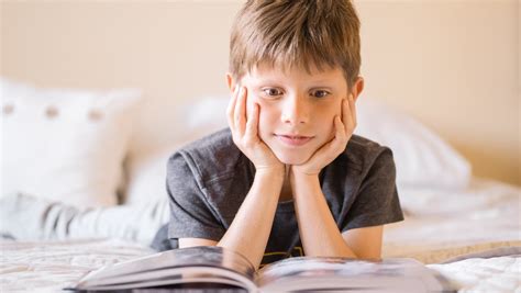 Selective Focus Photo Of An Amazed Boy Reading A Book · Free Stock Photo