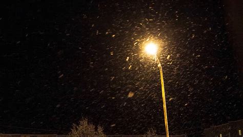 Snow Falling By Night Near A Street Lamp Stock Footage