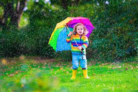 Kids Playing In The Rain Under Colorful Umbrella Stock Photo By
