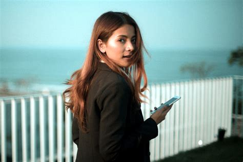 Free Picture Woman Looking Back Holding Smartphone