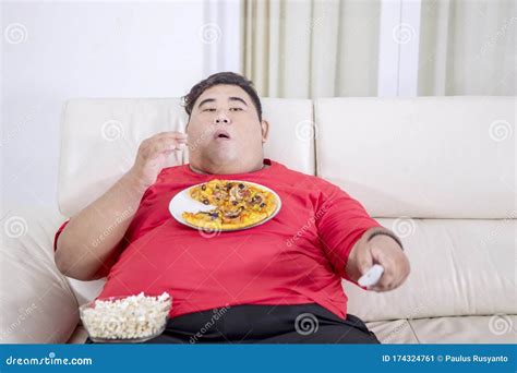 Fat Man Chewing Popcorns While Holding A Tv Remote Stock Image Image