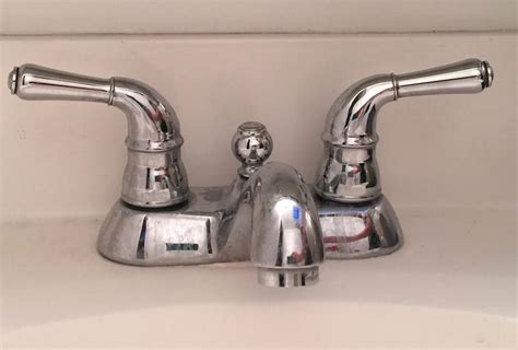 This faucet fits sinks / vanities with three drill holes. bathroom fixtures - How to remove the handles from this ...