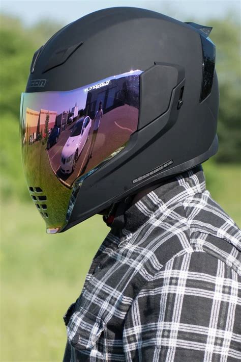 A Person Wearing A Helmet With A Car Reflection On The Visor And