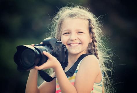 Positive Female Child Taking Pictures With Camera In Park Stock Image