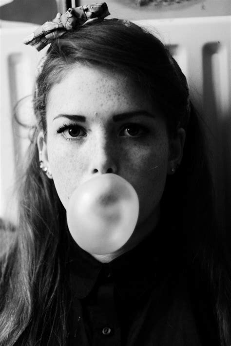 a woman with long hair blowing bubbles in her mouth