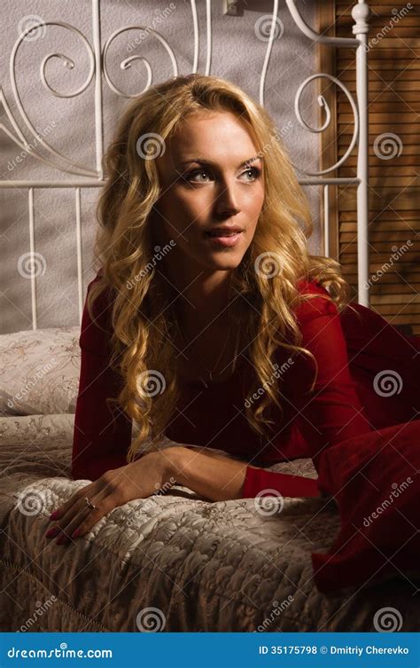 Sensual Blonde In A Red Dress Lying On The Bed Stock Photo Image Of
