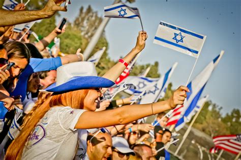 A Group Of People Waving Israeli And American Flags