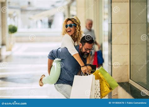 Couple Of Adults Falling In Love Together And Doing Shopping In A Mall Having Fun Man Holding