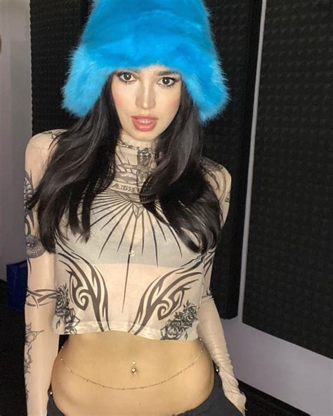 a woman with long black hair wearing a blue fur hat on top of her head