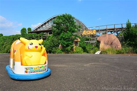 An Inflatable Toy Sits On The Ground Near A Roller Coaster