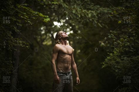 Shirtless Man In Woods Looking Up At Sky Stock Photo OFFSET