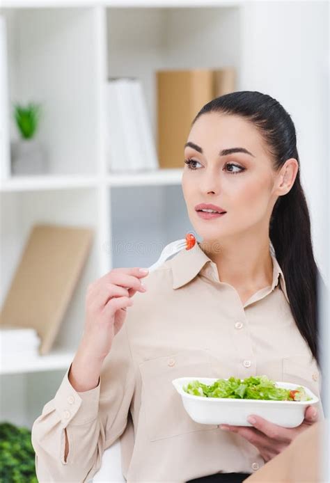 Portrait Of Businesswoman Eating Take Away Salad For Lunch Stock Photo