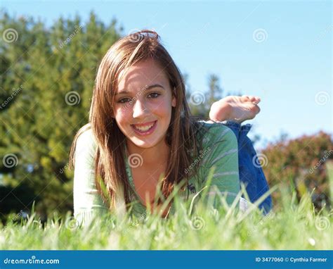 Teenage Boy Laying In Park Using Mobile Phone Stock Photography