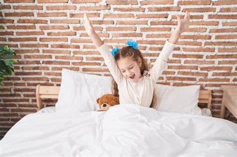 Adorable Caucasian Girl Waking Up Stretching Arms At Bedroom Stock