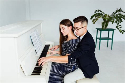 Free Photo Handsome Young Man Playing Piano By Looking At Musical Sheet