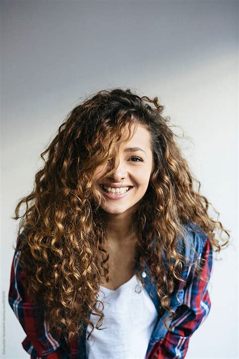 Portrait Of Beautiful Young Woman With Curly Hair Laughing At Camera By Stocksy Contributor