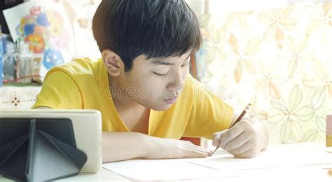 Asian Mother Helping Her Son Doing Homework On White Table Stock Image