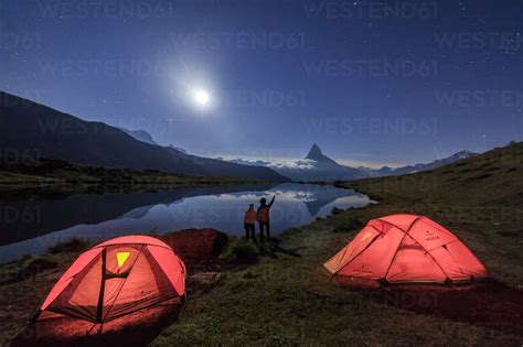 Hikers Admire Matterhorn Reflected In Lake Stellisee On A Starry Night