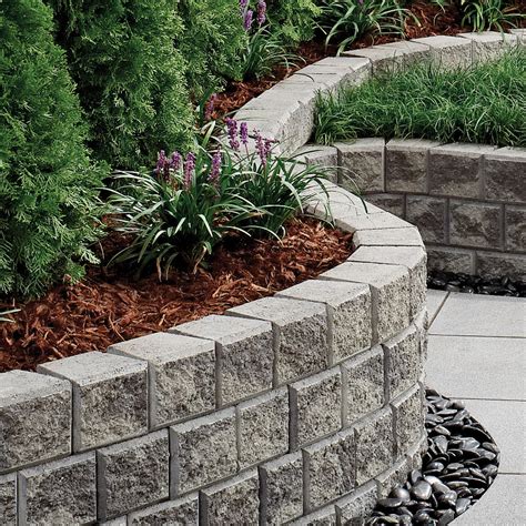 A cinder block retaining wall needs a poured concrete or gravel foundation, footings, and grout filling and rebar for support. Firth Retaining Walls & Fences | Concrete Retaining Walls