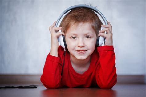 Los Niños Escuchan Música En Casa Niño Con Auriculares Foto Premium