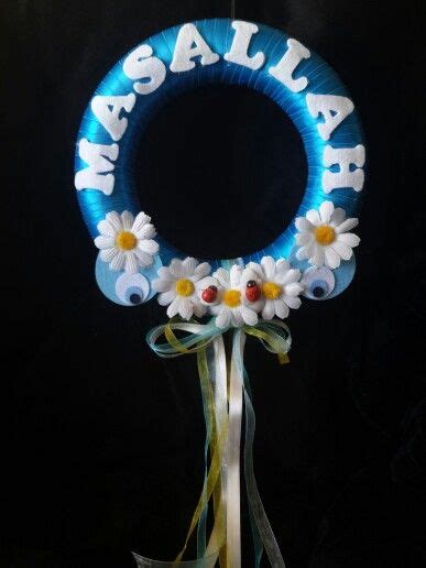 A Blue Wreath With Daisies And The Words Masalaha On It Hanging From A