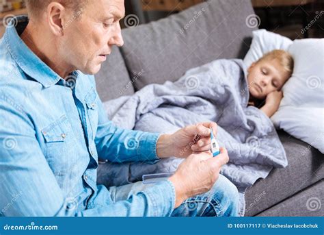 Concerned Father Checking Temperature Of His Sick Son Stock Image