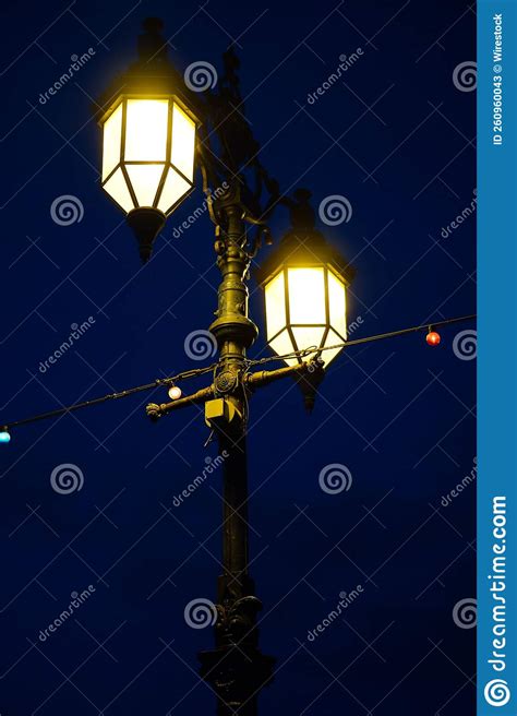 Close Up View Of A Traditional European Streetlight Pole Lit At Night