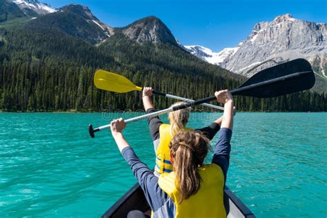 Two Adult Woman Paddle On A Canoe On Emerald Lake In Yoho National Park