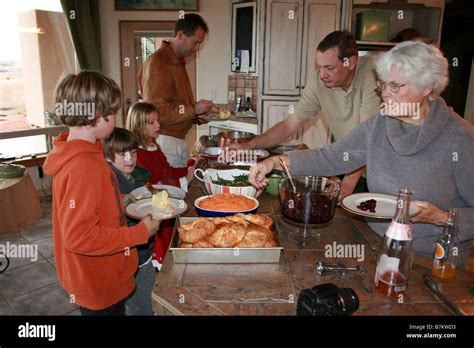 family serving themselves thanksgiving dinner buffet style at home