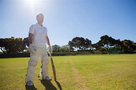 Cricket Player With Bat Standing On Grassy Field Stock Photo Image Of
