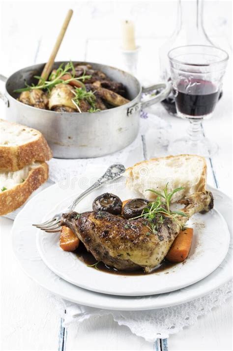 Traditional French Coq Au Vin With Chicken Leg And Mushrooms In Red Wine In A Traditional Plate