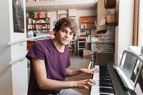 Adolescent Jouant Du Piano Et Regardant La Caméra Photo Gratuite