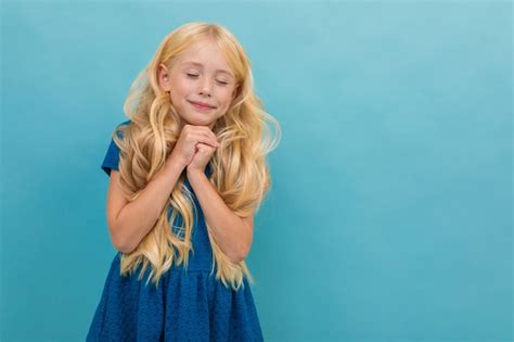 Premium Photo Little Girl With Blonde Hair In Blue Dress Is Relaxed