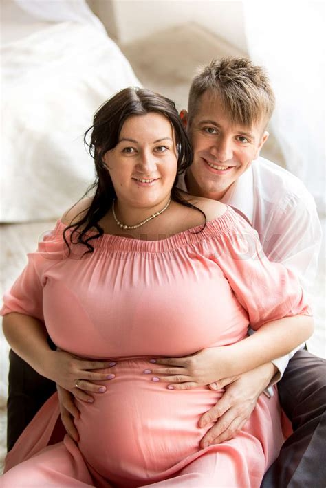 portrait of handsome man hugging pregnant wife from back stock image colourbox