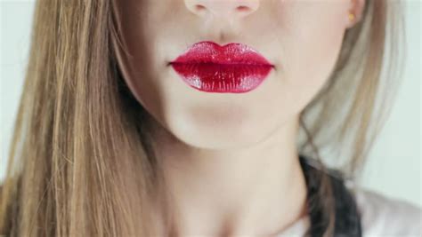 The Little Cute Girl Makes Up Lips With Red Lipstick And Kisses On The