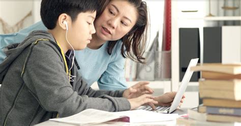 asian mother helping her son doing homework on white table stock image image of caucasian