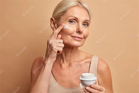 Free Photo Middle Aged Beautiful Woman Applies Anti Aging Cream On Face Undergoes Beauty
