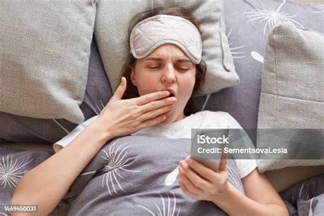 photo libre de droit de plan intérieur dune jeune femme fatiguée et endormie portant un masque